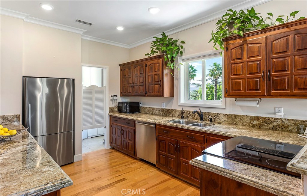 12822 Periwinkle Drive North Tustin, CA 92705 - Photo 33 of 36 a kitchen with stainless steel appliances granite countertop a sink stove and refrigerator