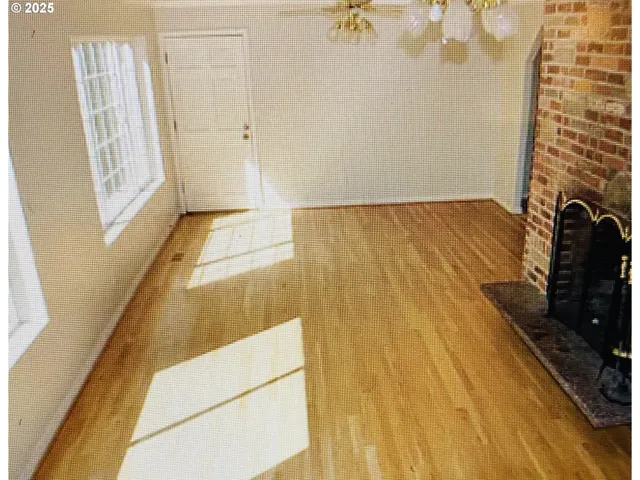 a view of an empty room and chandelier fan