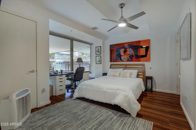 a bedroom with a bed and a large window