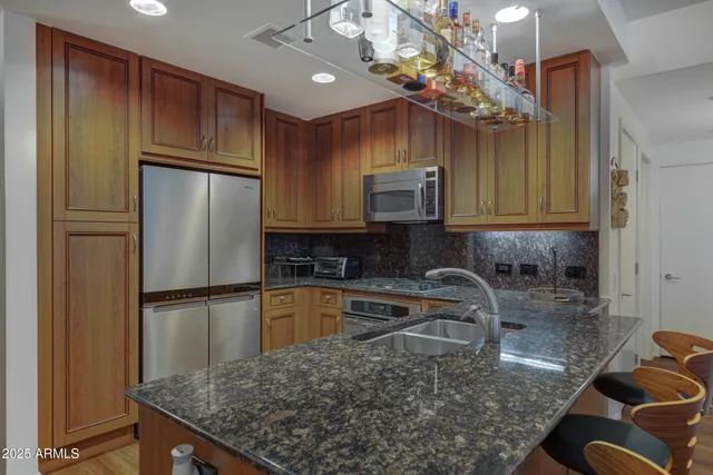 a kitchen with stainless steel appliances granite countertop a sink refrigerator and microwave