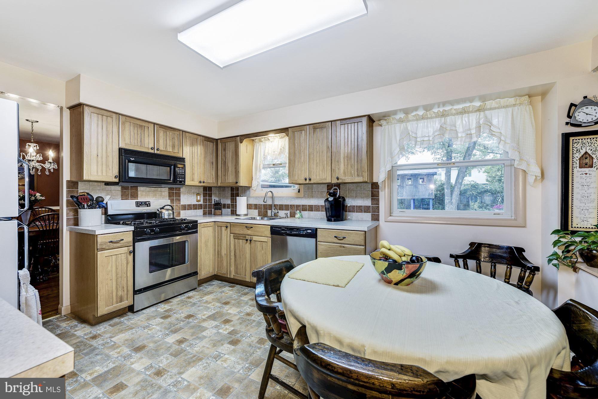 207 Regency Road Edgewater Park, NJ 08010 - Photo 21 of 36 a kitchen with a stove a sink a dining table and chairs