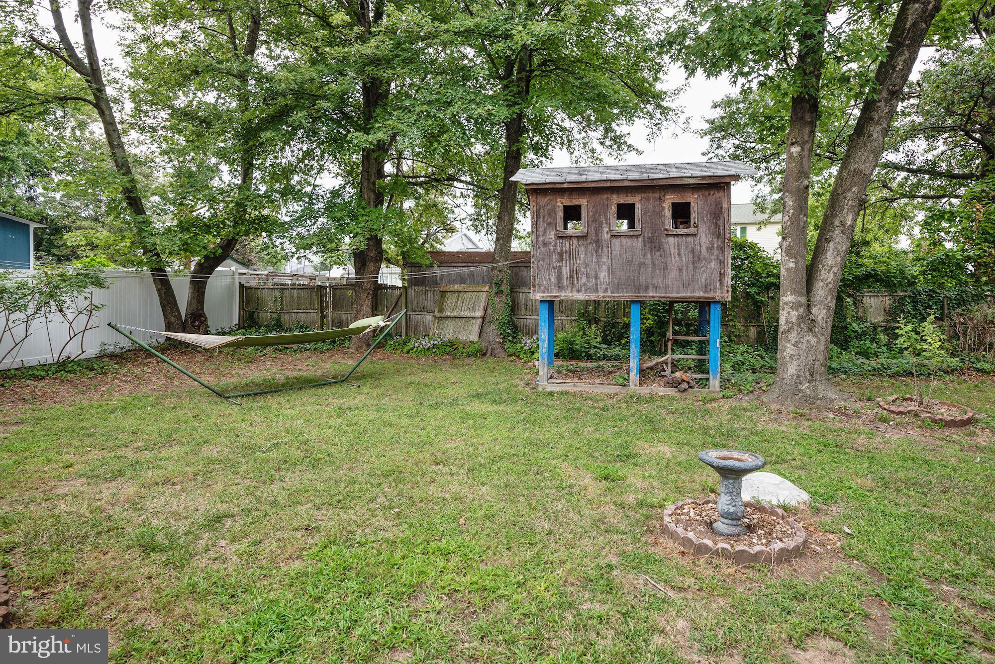 207 Regency Road Edgewater Park, NJ 08010 - Photo 10 of 36 a front view of a house with a garden and trees
