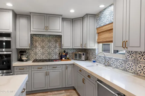 a kitchen with stainless steel appliances granite countertop a sink stove and cabinets