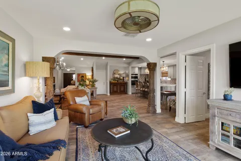 a living room with furniture a rug and kitchen view