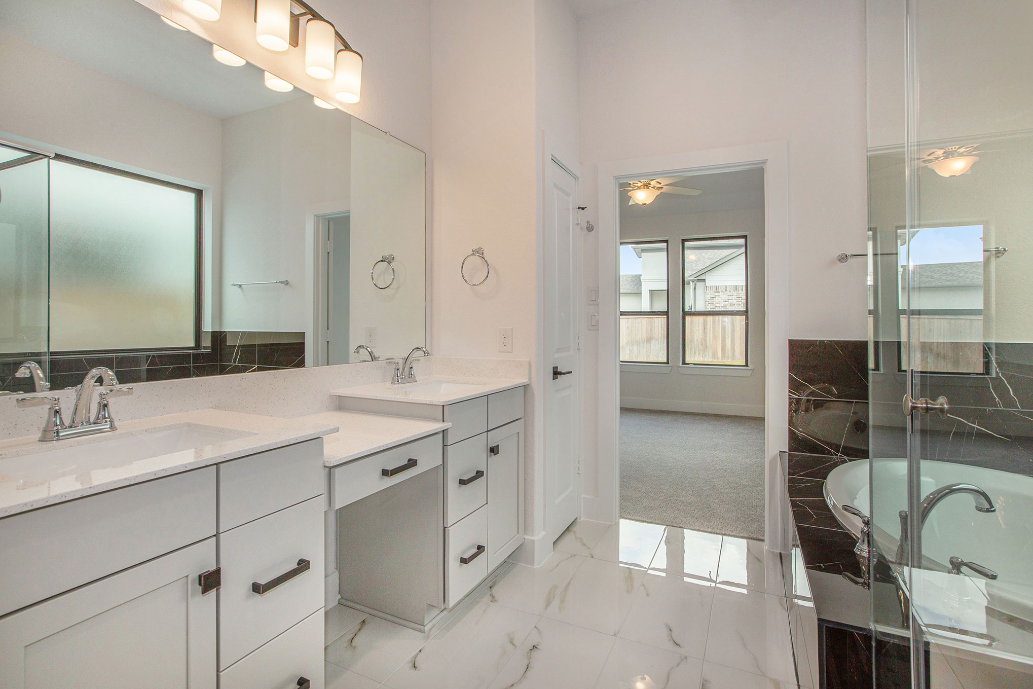 15018 Bonham Shore Drive Cypress, TX 77433 - Photo 20 of 31 a en suite bathroom with a double vanity sink a mirror and a shower