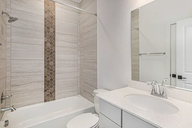 a bathroom with a sink toilet vanity and shower