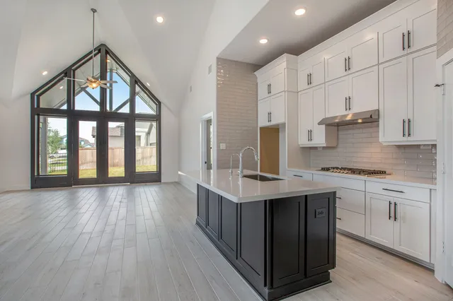 a kitchen with stainless steel appliances granite countertop a stove and cabinets