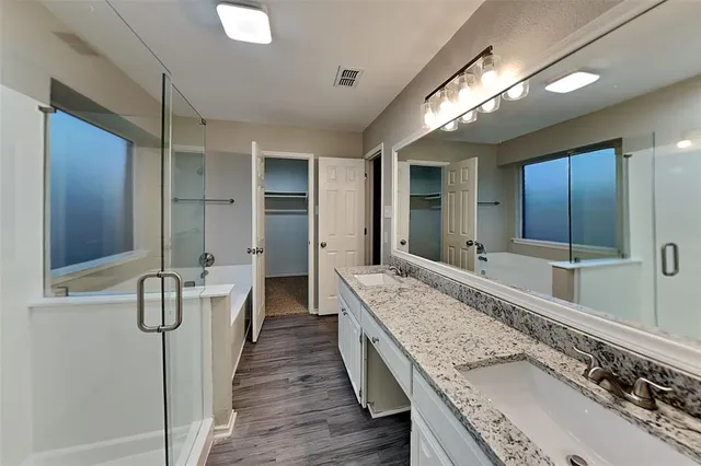 a spacious bathroom with a tub shower and sink