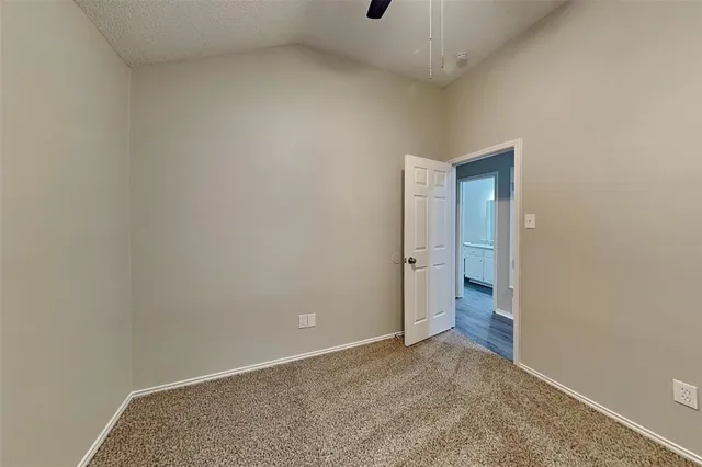 an empty room with chandelier fan