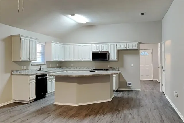 a kitchen with a sink cabinets and wooden floor