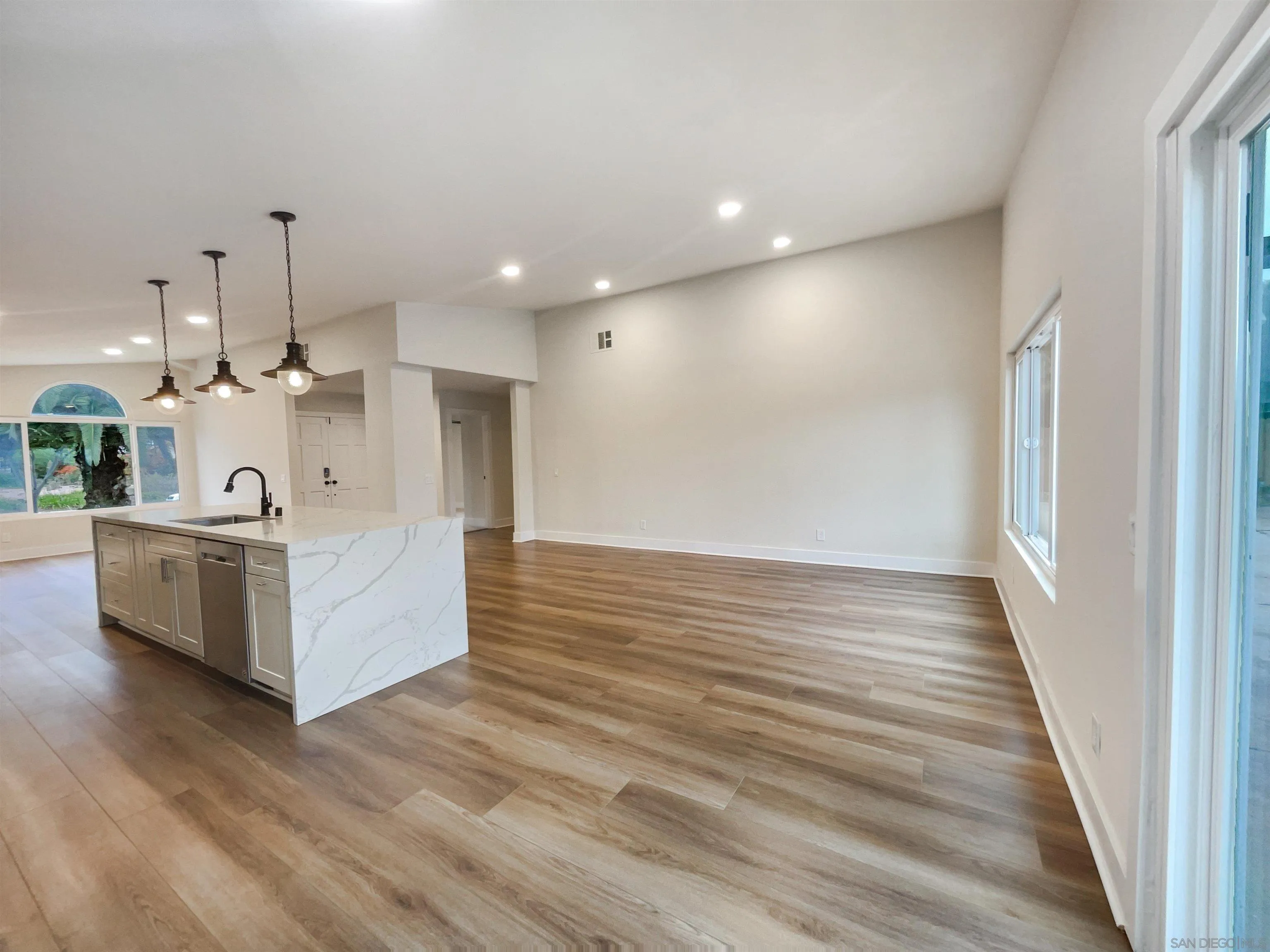 350 Whispering Brook Drive Vista, CA 92083 - Photo 11 of 17 a view of a kitchen with kitchen island a sink wooden floor and a fireplace