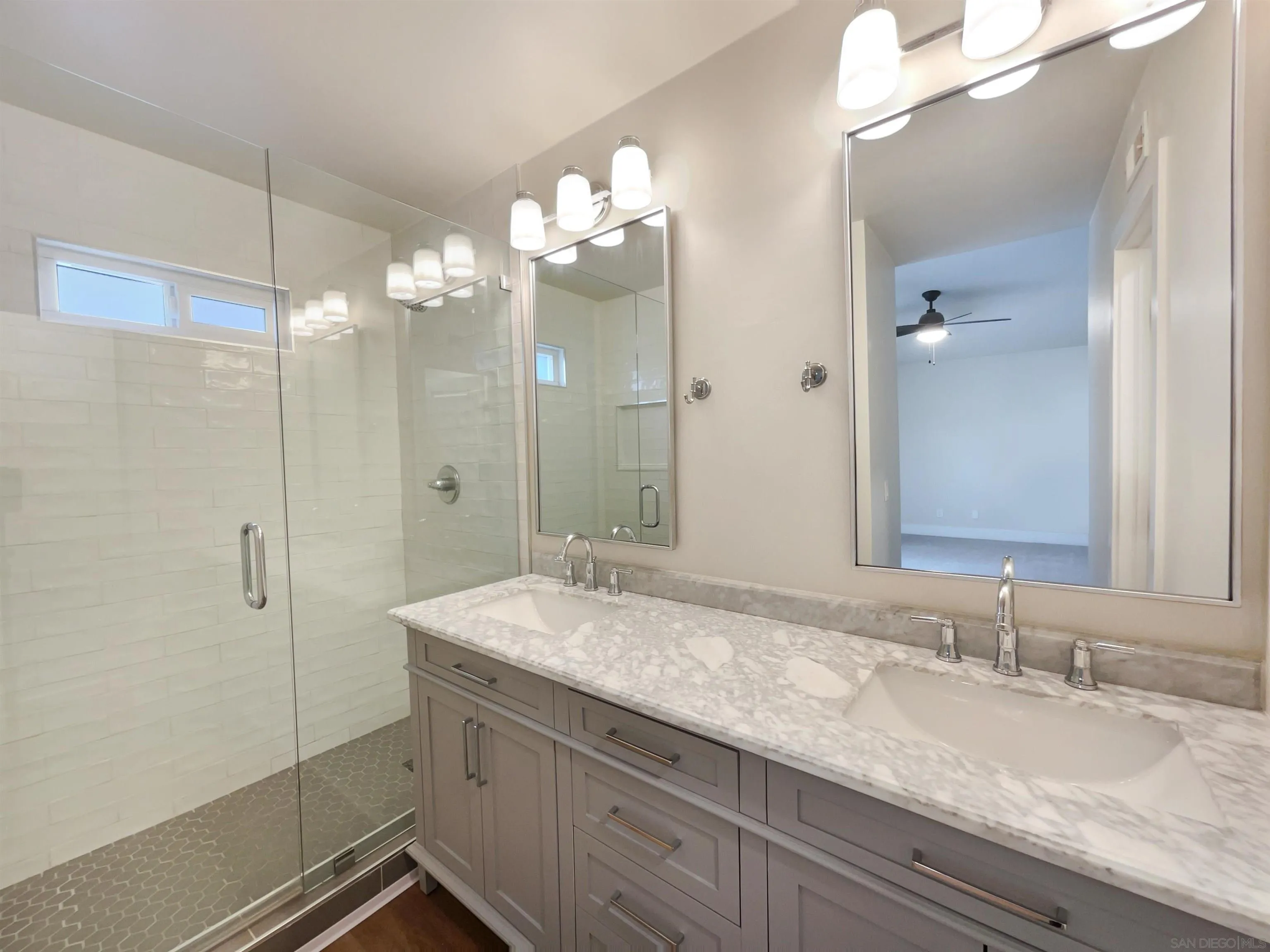 350 Whispering Brook Drive Vista, CA 92083 - Photo 16 of 17 a bathroom with a granite countertop sink a large mirror and a shower