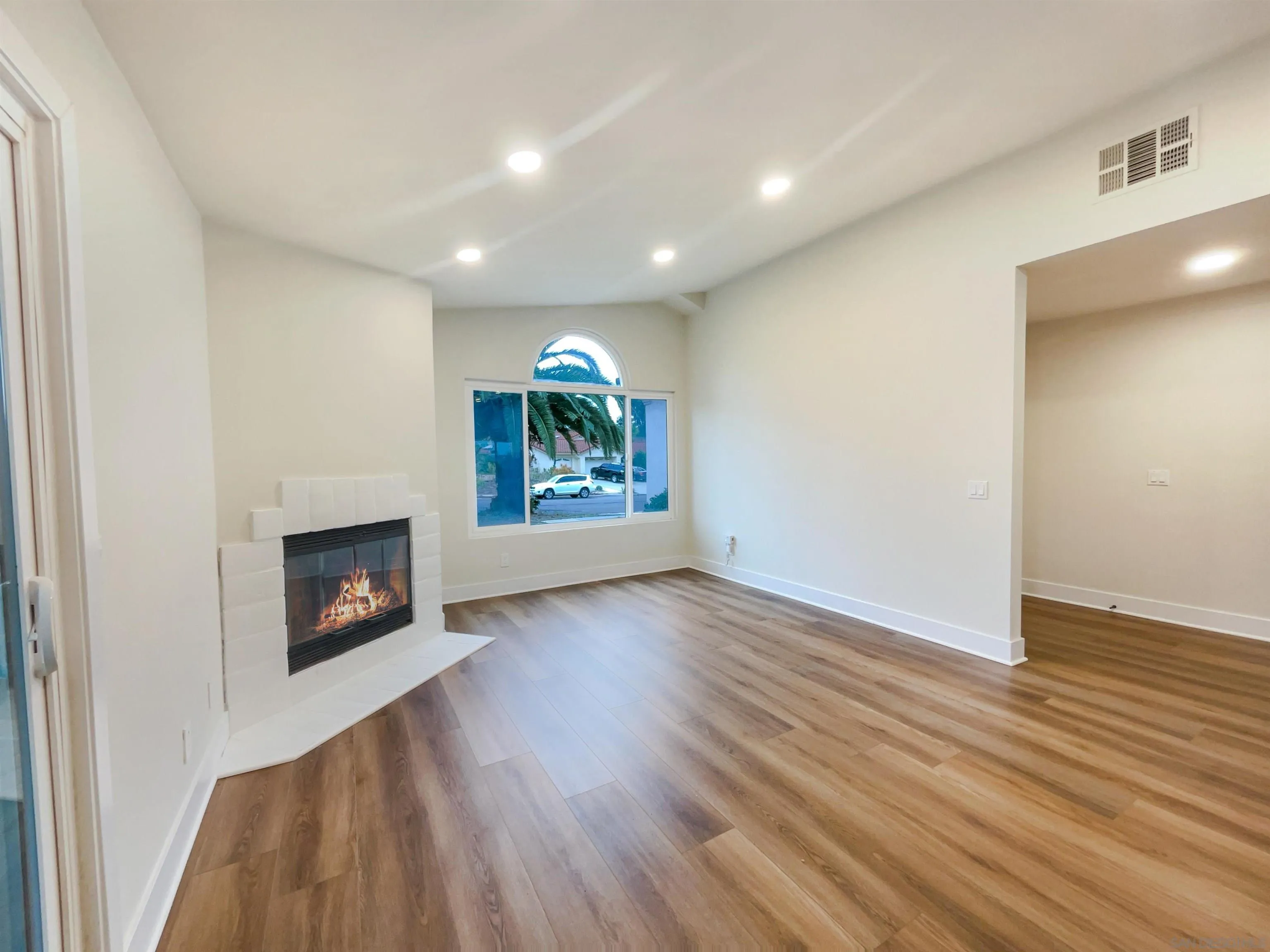 350 Whispering Brook Drive Vista, CA 92083 - Photo 3 of 17 an empty room with wooden floor and a fireplace