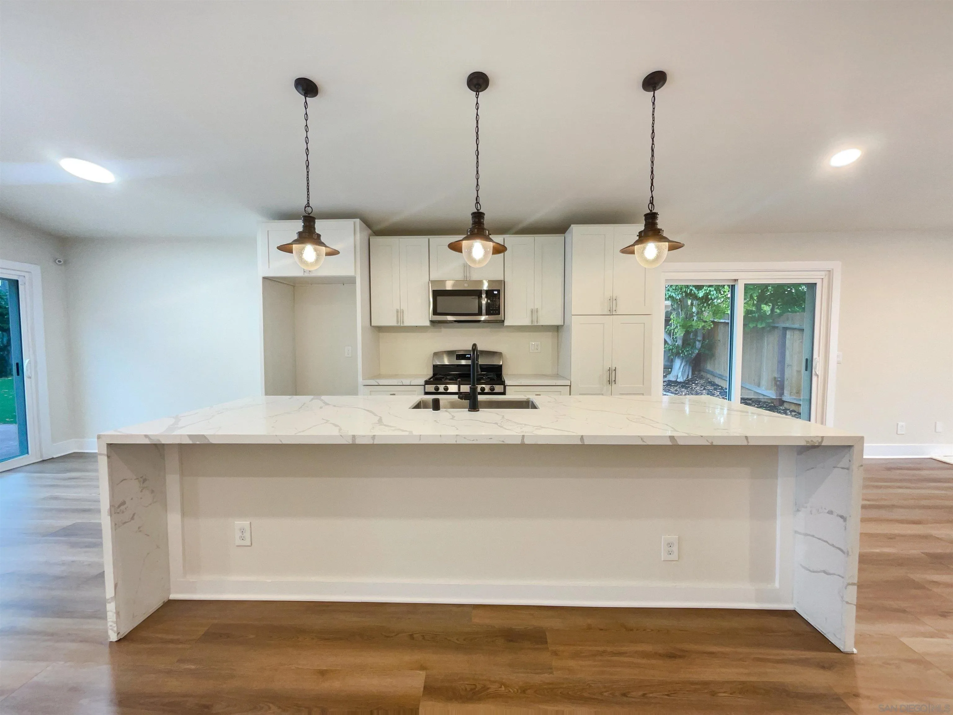 350 Whispering Brook Drive Vista, CA 92083 - Photo 10 of 17 a view of a kitchen with appliances cabinets and a wooden floor