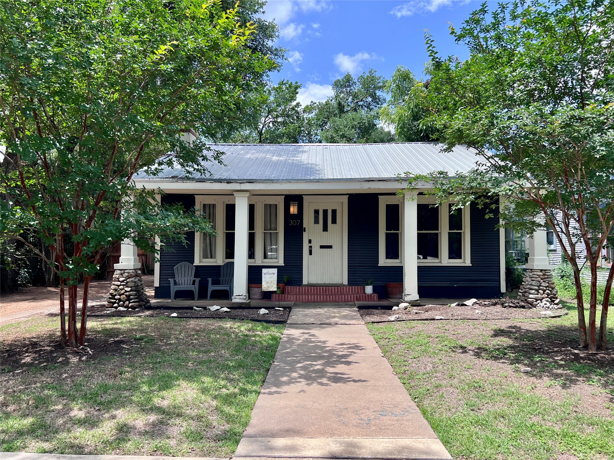 307 East 35th Street, Unit A Austin, TX 78705 - Photo 1 of 31 A charming façade features a covered front porch with classic columns and stone bases.