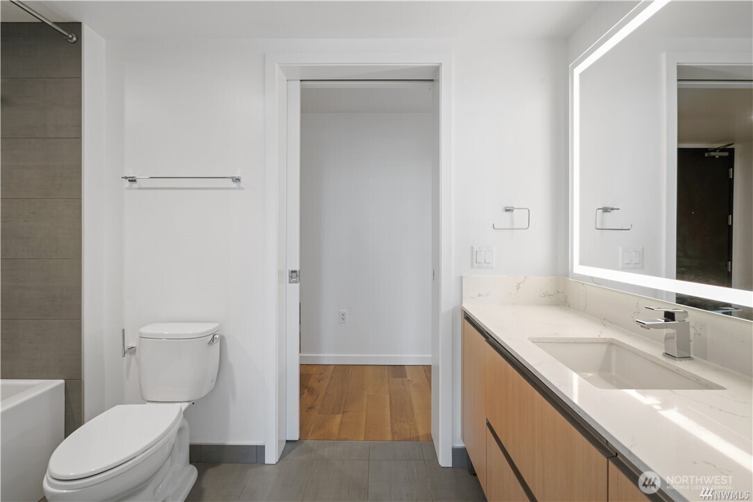 1808 Minor Avenue, Unit 905 Seattle, WA 98101 - Photo 8 of 33 a bathroom with a granite countertop toilet a sink and a mirror