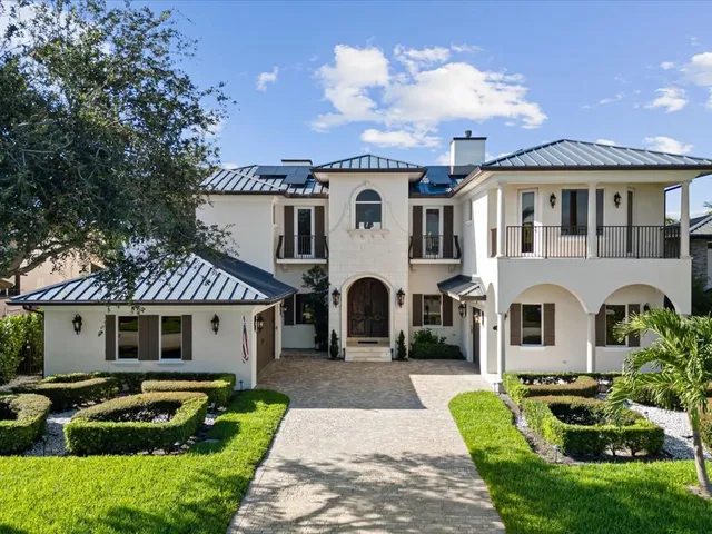 a front view of a house with a garden and plants