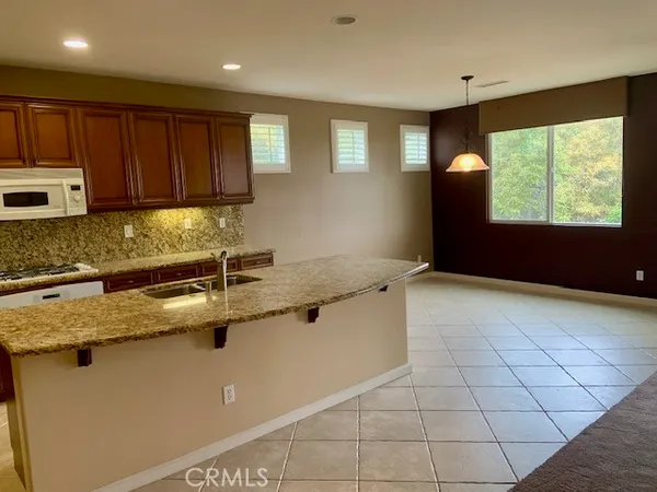 a kitchen with kitchen island granite countertop a sink window and cabinets