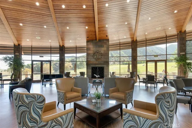 a living room with fireplace furniture and floor to ceiling windows