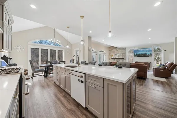 a kitchen with lots of counter space a sink appliances and living room view
