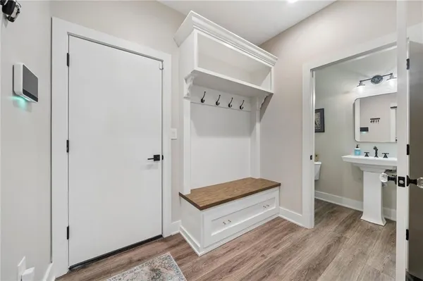 a view of hallway with a mirror and a wooden floor