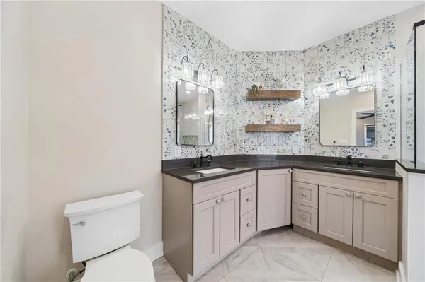a bathroom with a granite countertop sink a toilet and a mirror