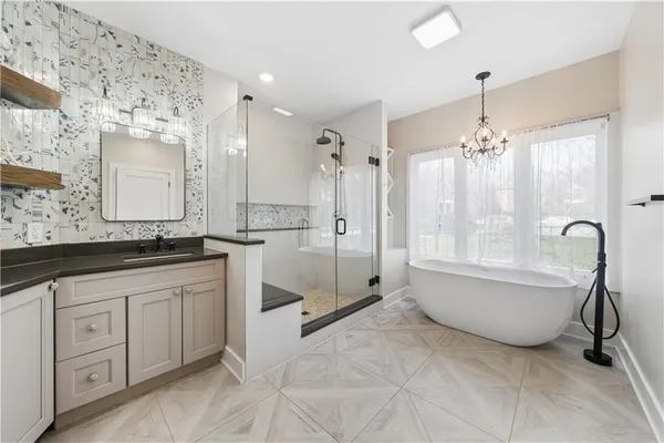 a spacious bathroom with a granite countertop sink mirror and a bath tub