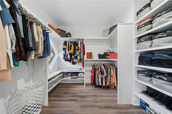 a view of walk in closet with clothes and shoes