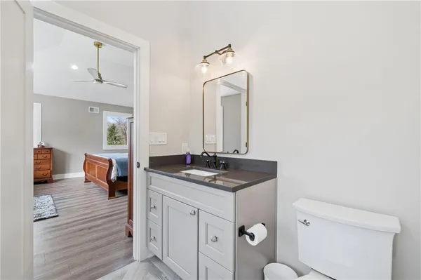 a en suite bathroom with a granite countertop sink and a mirror