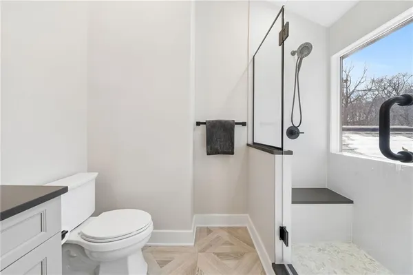 a bathroom with a toilet and a shower