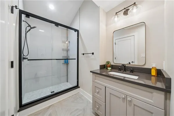 a bathroom with a shower sink and mirror