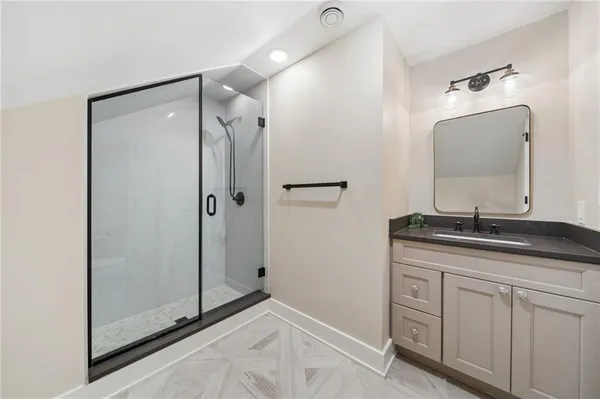 a bathroom with a granite countertop sink mirror and shower