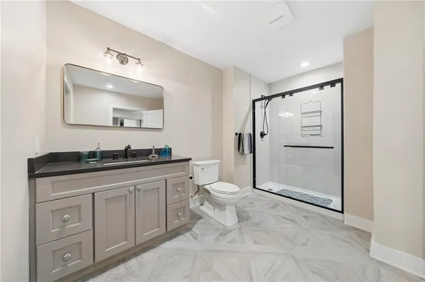 a spacious bathroom with a granite countertop sink toilet and shower