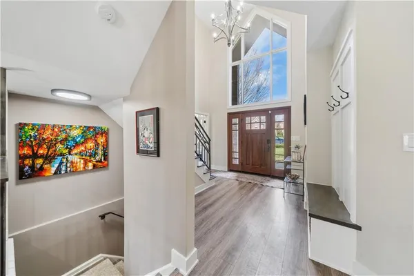 a view of a hallway with wooden floor and front door