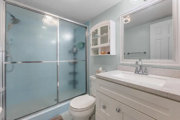 a bathroom with a sink a toilet and shower