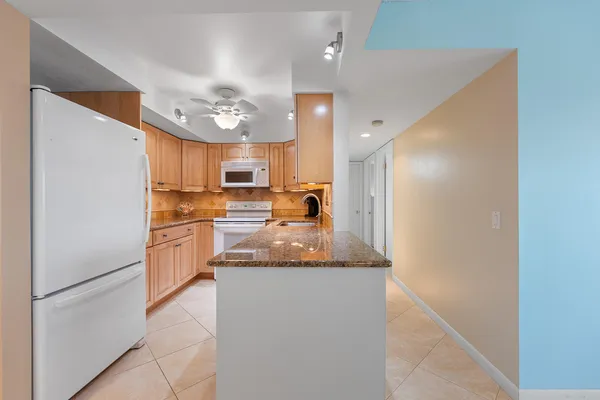 a kitchen with granite countertop a refrigerator oven a sink and dishwasher