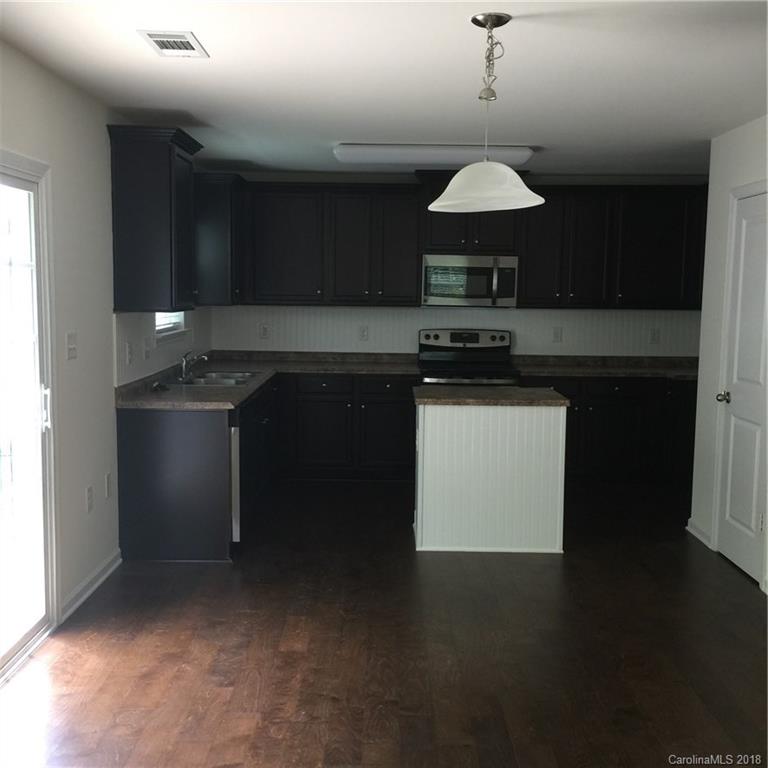 3018 Arthur Road, Unit 165 Indian Land, SC 29707 - Photo 4 of 19 a kitchen with stainless steel appliances granite countertop a stove a sink and a microwave