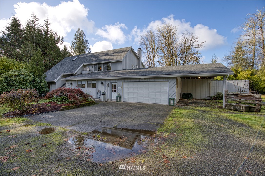 a front view of a house with a garden and trees