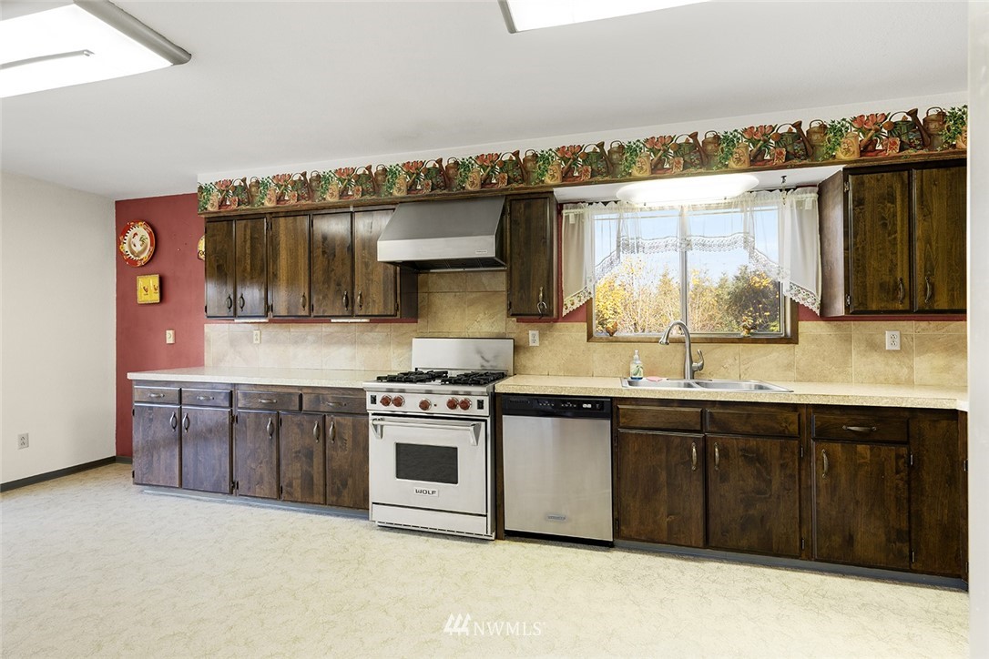 1381 Wynoochee Valley Road Montesano, WA 98563 - Photo 11 of 40 a kitchen with stainless steel appliances granite countertop a stove a sink and a microwave