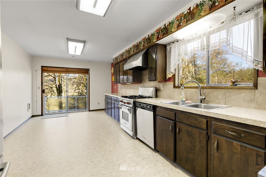 1381 Wynoochee Valley Road Montesano, WA 98563 - Photo 12 of 40 a open kitchen with stainless steel appliances granite countertop a sink a stove and a refrigerator