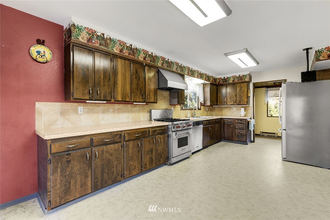1381 Wynoochee Valley Road Montesano, WA 98563 - Photo 10 of 40 a kitchen with stainless steel appliances a sink cabinets and a counter top space