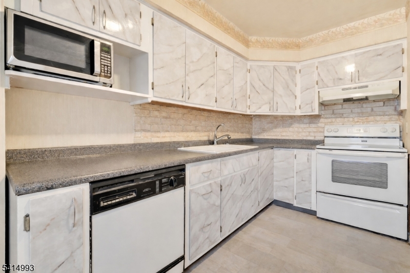 627 East Vail Road Landing, NJ 07850 - Photo 9 of 26 a kitchen with stainless steel appliances white cabinets and a stove top oven