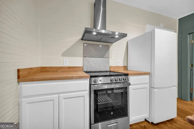 a kitchen with a stove and white cabinets
