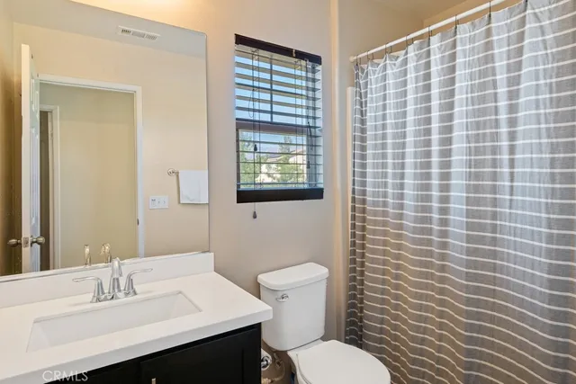 a bathroom with a sink a toilet and mirror