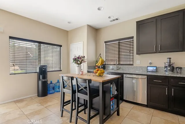 a kitchen with a table chairs sink and cabinets