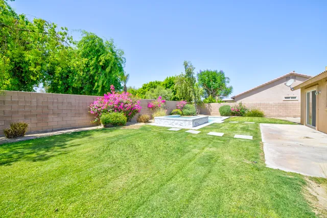 a view of a table and chairs in back yard of the house