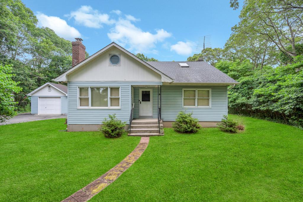a front view of a house with yard and green space