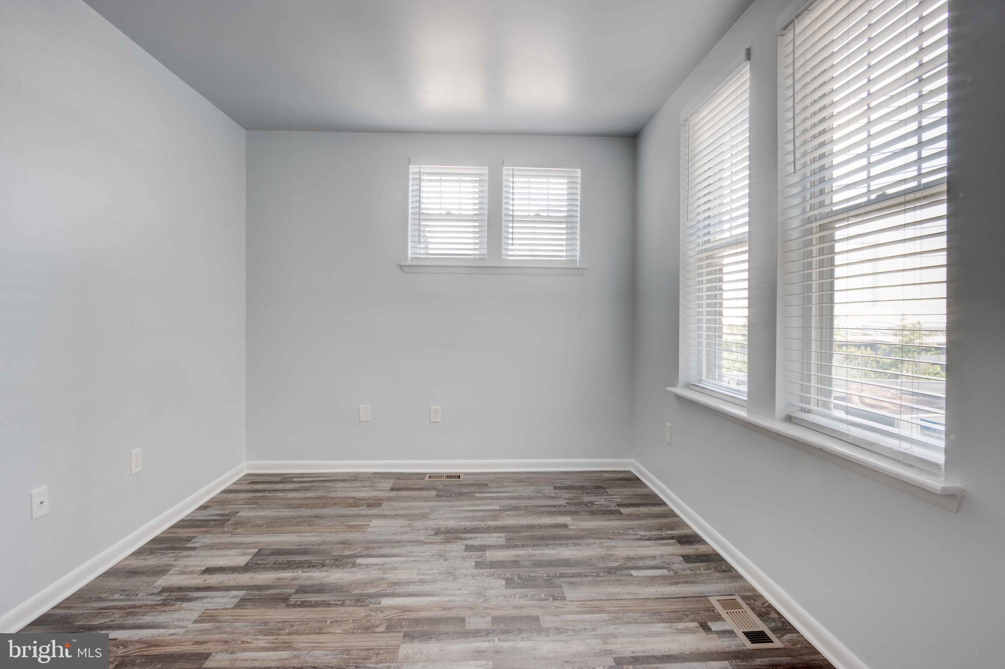 951 Brooks Lane, Unit 1C Baltimore, MD 21217 - Photo 12 of 21 a view of an empty room with wooden floor and a window