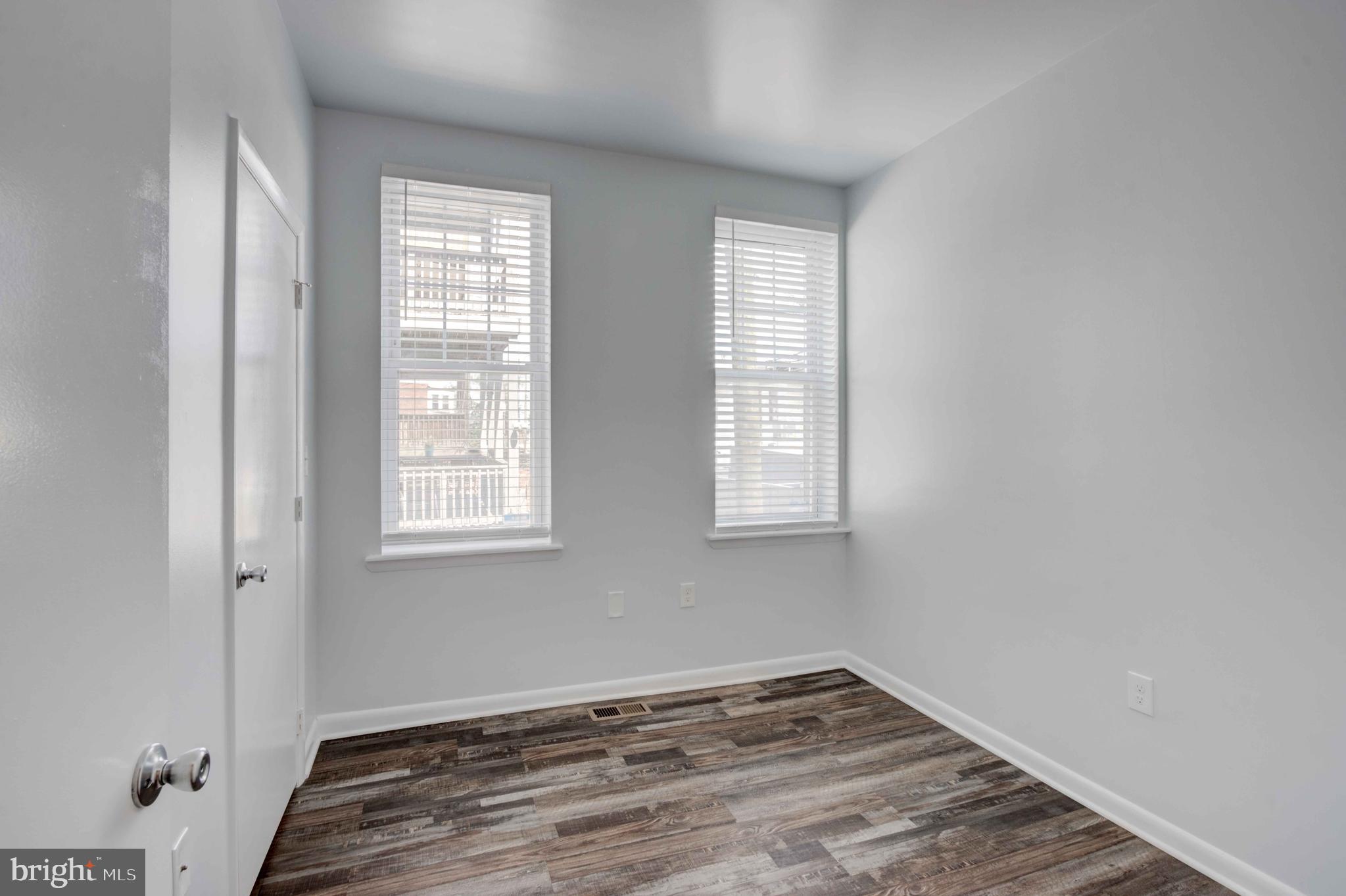 951 Brooks Lane, Unit 1C Baltimore, MD 21217 - Photo 14 of 21 an empty room with wooden floor and windows