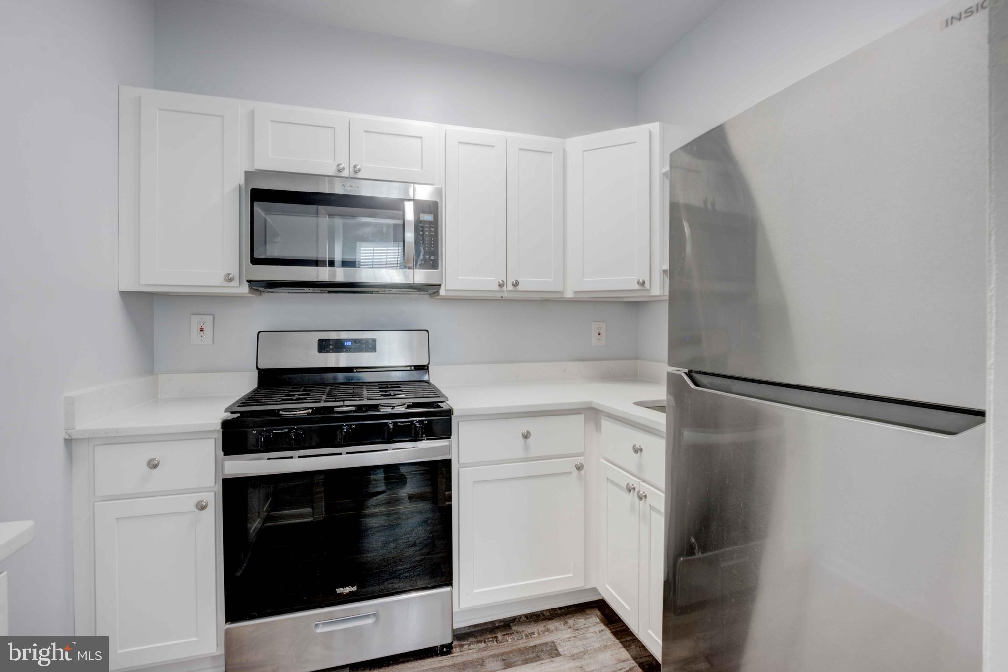 951 Brooks Lane, Unit 1C Baltimore, MD 21217 - Photo 7 of 21 a kitchen with white cabinets and stainless steel appliances